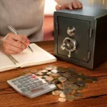 "Cofrinho com moedas, caderno de planejamento financeiro e calculadora, representando a construção de um fundo de emergência."